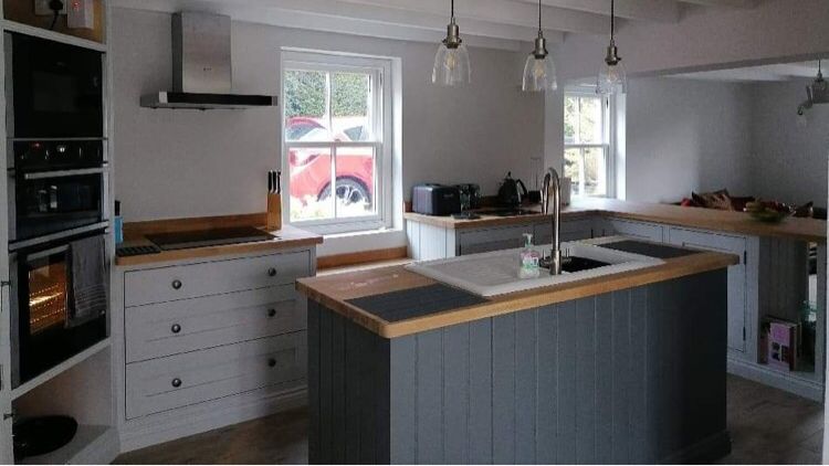 Painted kitchen with a panelled island and oak worktops