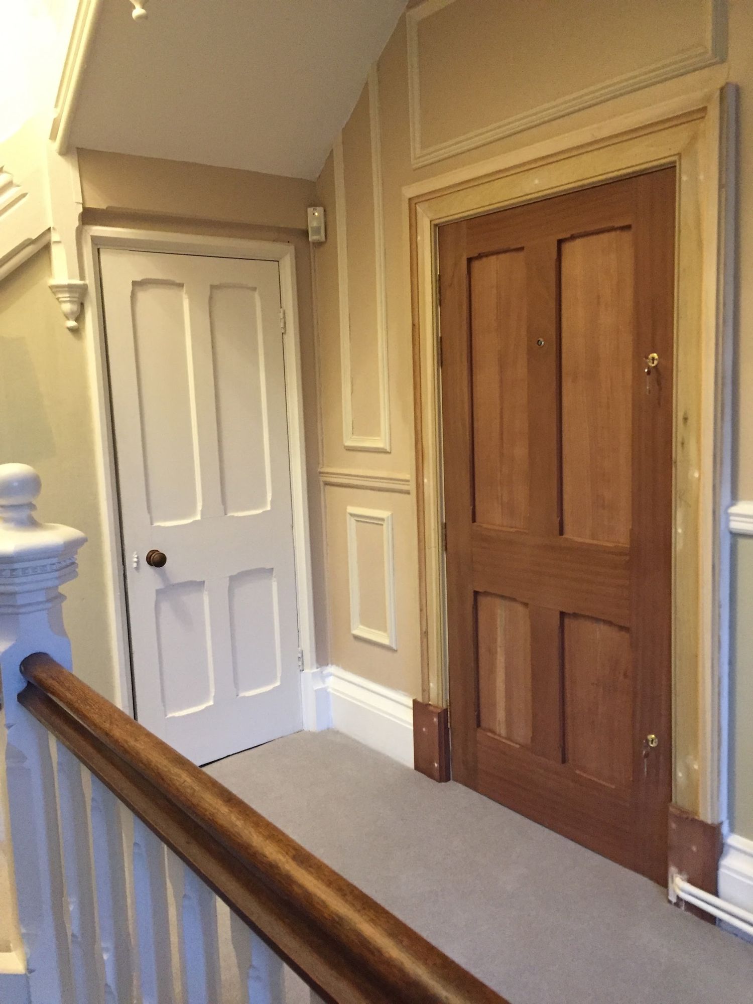 New hardwood four-panel door and lining fitted on a period landing